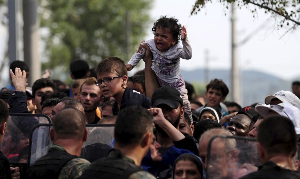 A baby cries at the border line dividing Macedonia and Greece